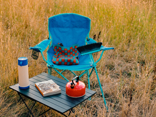 Camping gear set up outdoors in tall grass.